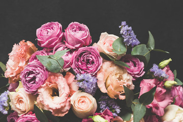 Bouquet of pink and purple peonies with eucalyptus on black concrete background. Toned image, Pastel bouquet of flowers