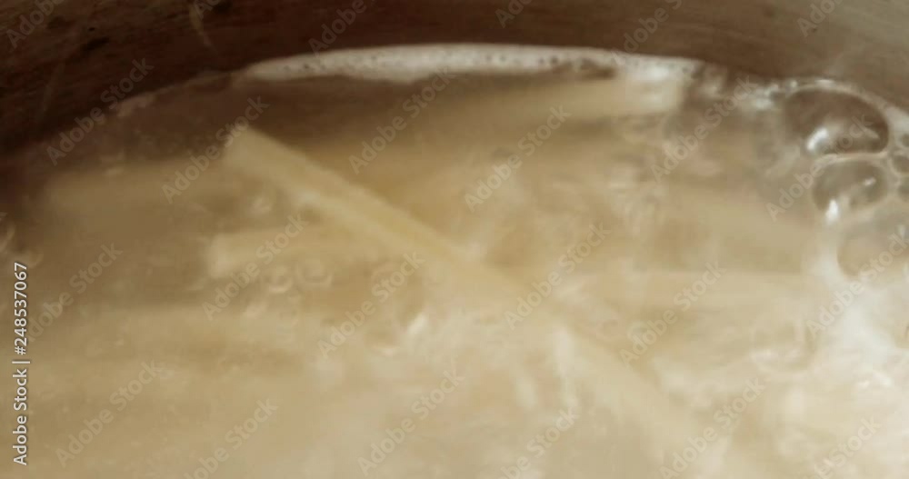 Very close-up of pan with boiling water and pasta Very close-up of pan with boiling water and pasta