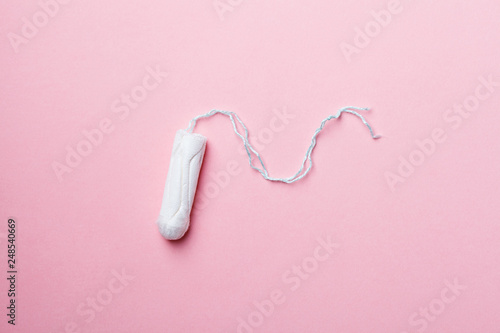 cotton tampon on pink background, flat layout, top view