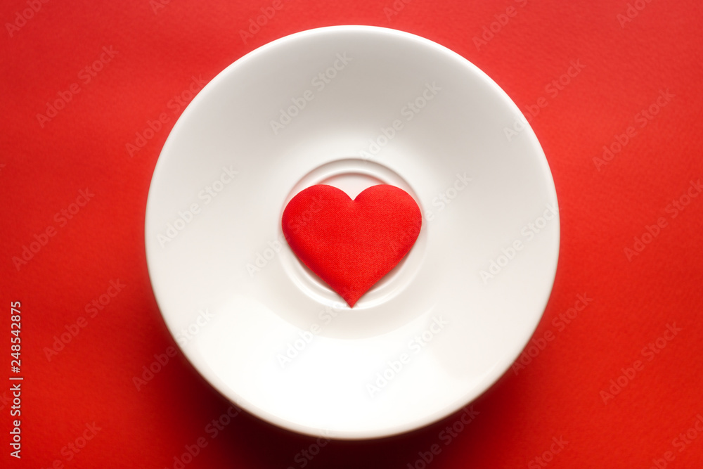 concept red heart at white dish. greeting card. copy space. relationships and humans. healthy lifestyle. for decor and design. concept red heart at white dish. greeting card. copy space. relationships and humans. healthy lifestyle. for decor and design.