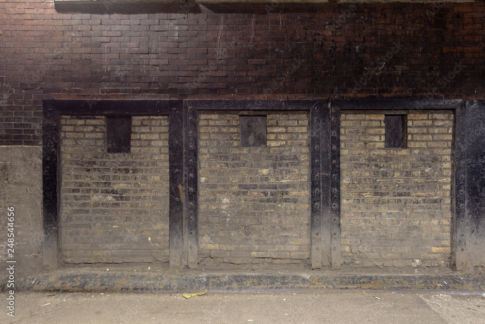 Naklejka premium Vintage two tone brick wall in urban alleyway
