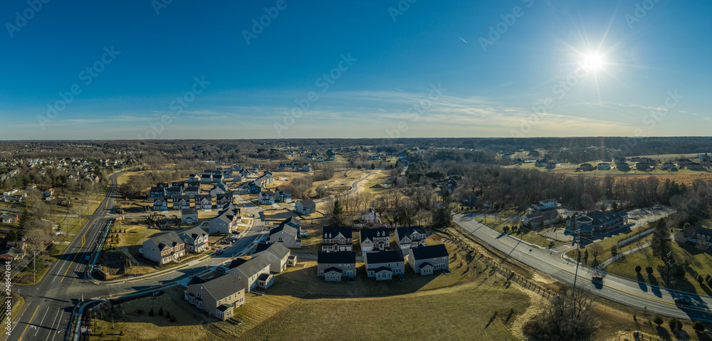Aerial panorama of American luxury traditional, contemporary single family home estates with gable roof, in a new residential suburban new construction neighborhood for upper middle class USA families