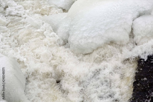Ice cold water splashes from flowing river