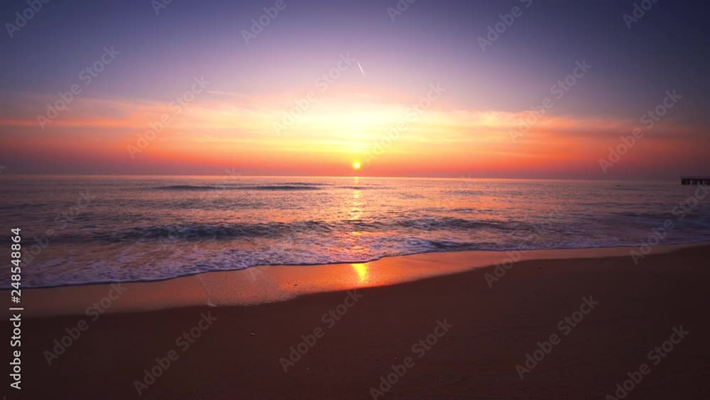 Sunrise over the sea and beach. Waves washing the sand. Sunrise over the sea and beach. Waves washing the sand.