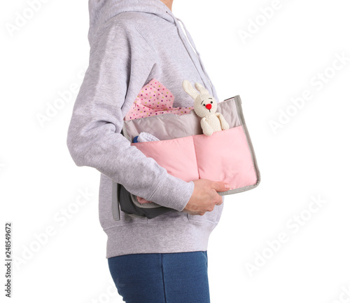 Woman holding maternity bag with baby accessories on white background, closeup