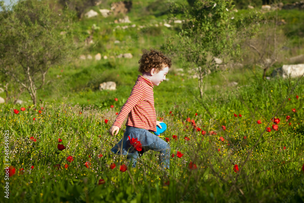 Cute little girl running on anemone meadow Cute little girl running on anemone meadow