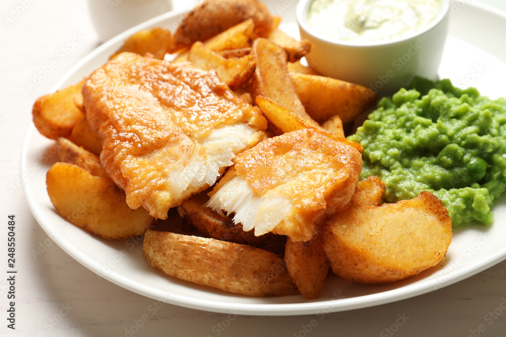 British Traditional Fish and potato chips on table, closeup British Traditional Fish and potato chips on table, closeup