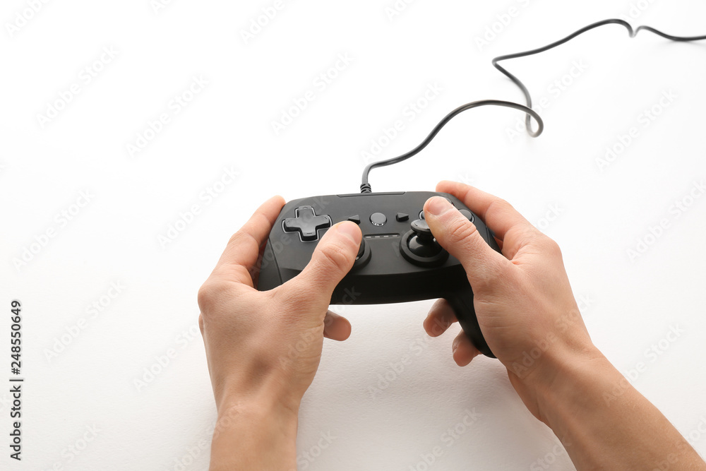 Young man holding video game controller on white background, closeup Young man holding video game controller on white background, closeup