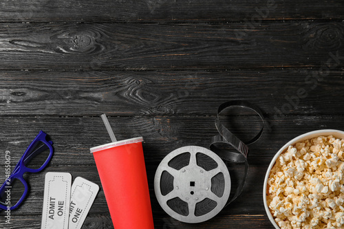 Flat lay composition with tickets, popcorn and space for text on wooden background. Cinema snack