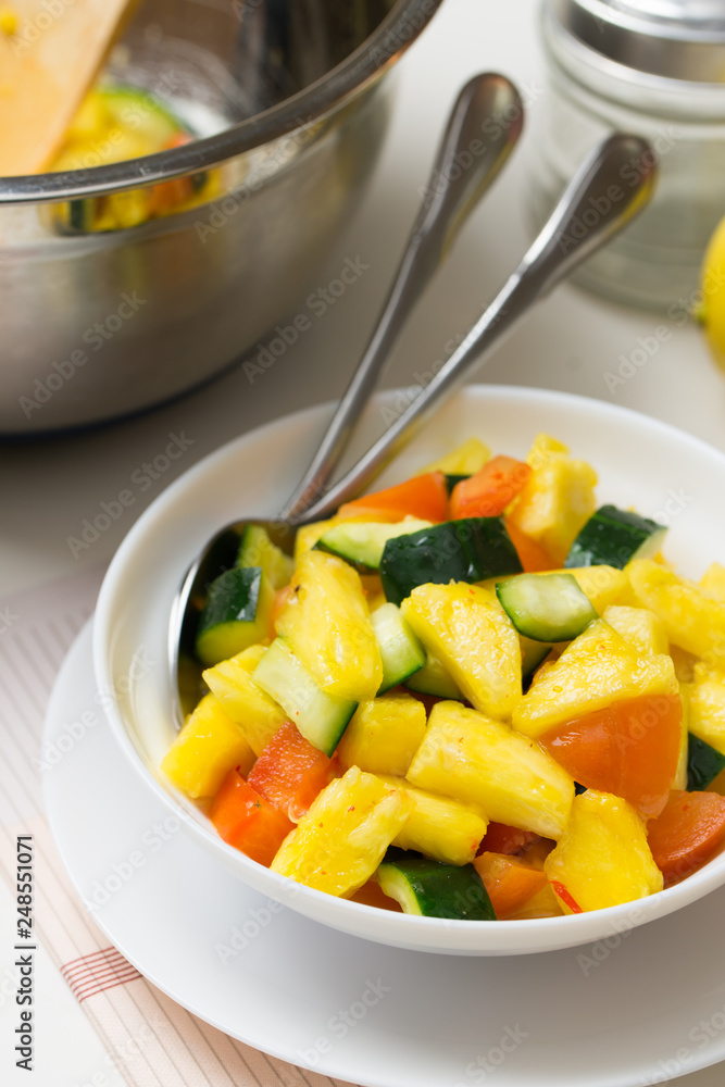 Fruit salad with pineapple, cucumber and tomato in bowl Fruit salad with pineapple, cucumber and tomato in bowl