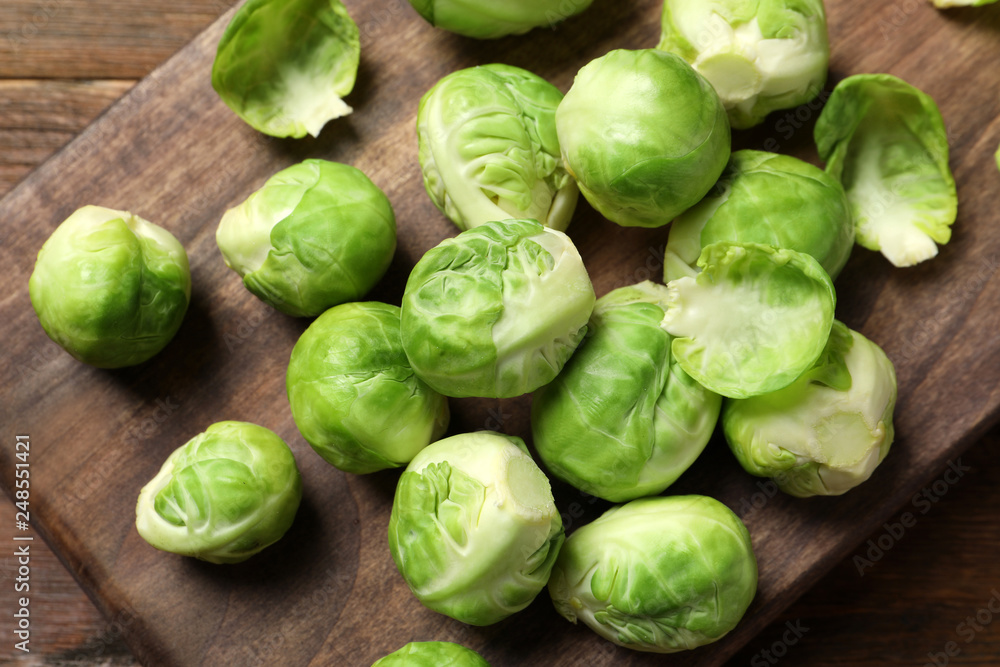 Board with Brussels sprouts on wooden background, top view Board with Brussels sprouts on wooden background, top view
