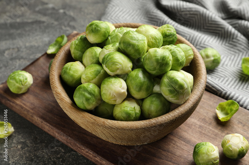 Board with bowl of Brussels sprouts on grey table