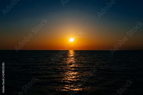 Sunset on the sea or ocean with beautiful blue sky. Sunset or sunrise scene landscape background concept image. © Hakan Tanak