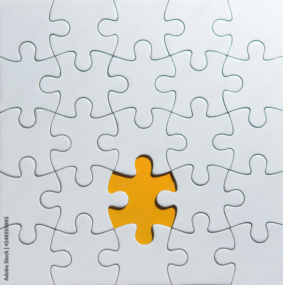 Unfinished white puzzle pieces on orange background Unfinished white puzzle pieces on orange background