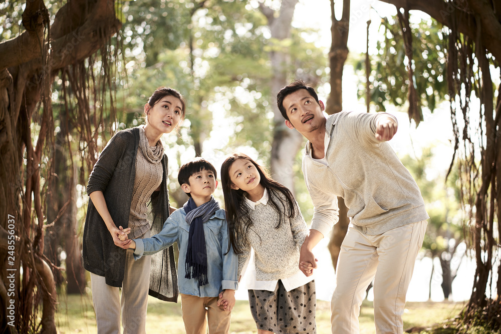 asian family with two children having fun in park asian family with two children having fun in park