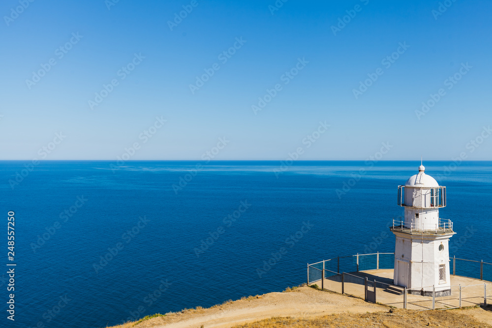 White lighthouse on a background of blue sea