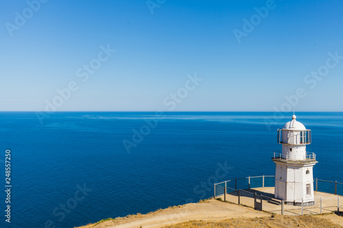 White lighthouse on a background of blue sea