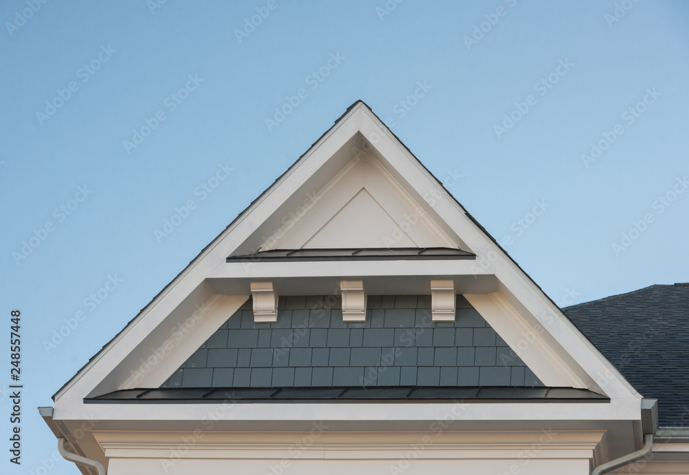 Plastic or wood roof decoration gable, corbel on a new construction luxury American single family home in the East Coast USA with blue sky background