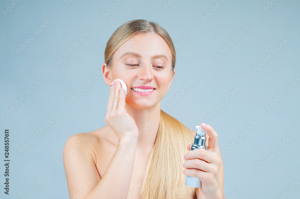 Facial treatment. Beautiful woman removing makeup from her face Facial treatment. Beautiful woman removing makeup from her face