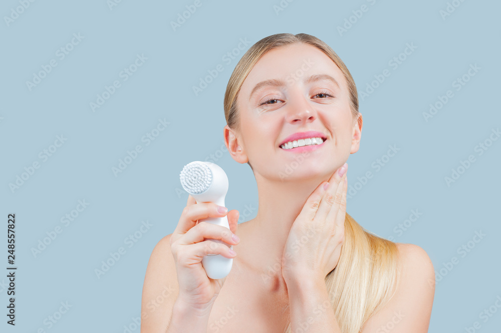 Beautiful woman is washing face skin with brush. Beautiful woman is washing face skin with brush.