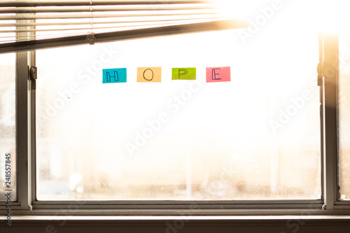 hope written on window with warm golden sunlight coming through.