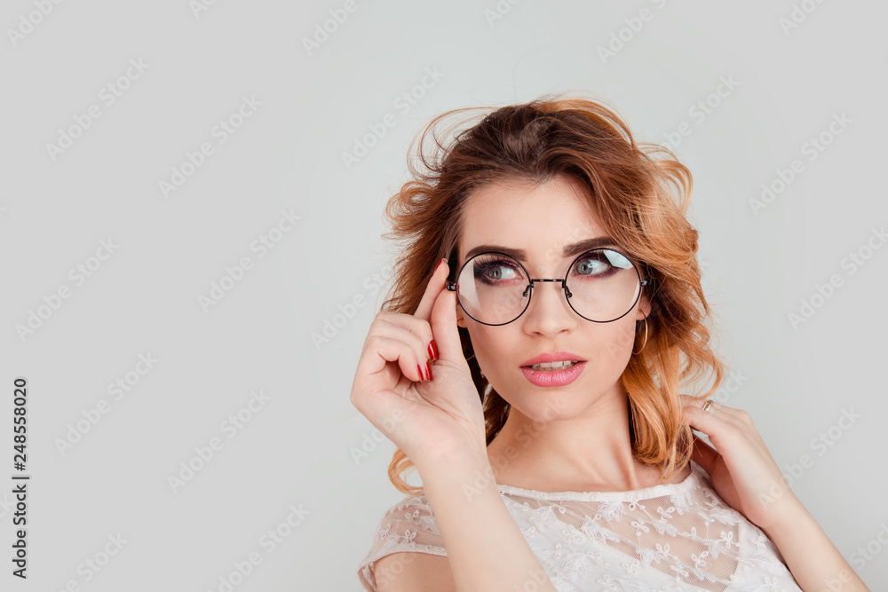 woman looking to the side wearing big round spectacles touching her eyeglasses woman looking to the side wearing big round spectacles touching her eyeglasses