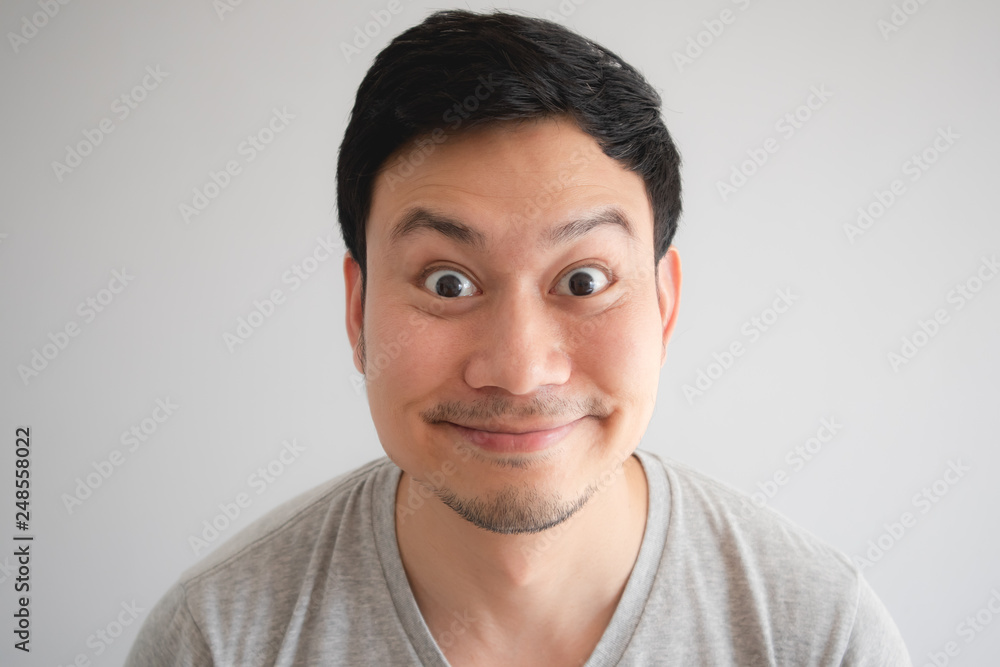 Very happy funny face of man with a big innocent smile in grey t-shirt Very happy funny face of man with a big innocent smile in grey t-shirt