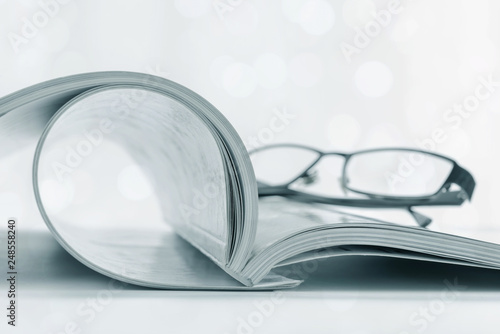 Open book and glasses light bokeh blur background.