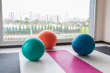 Colorful pilates balls and exercise sports equipments indoor concept image background. Gym interior.