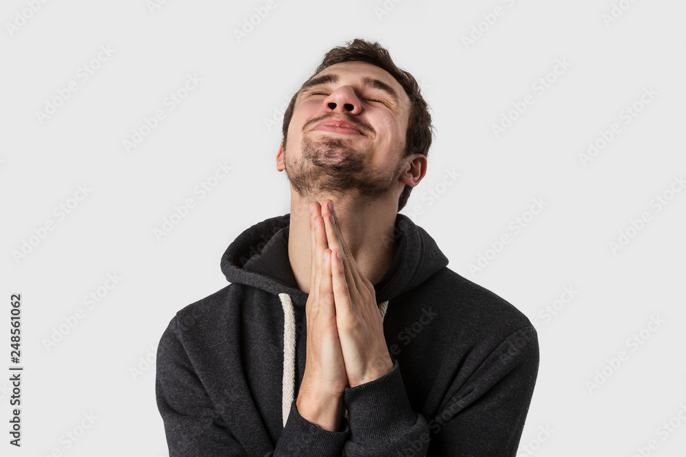 Young caucasian man praying. Isolated on white background. Young caucasian man praying. Isolated on white background.
