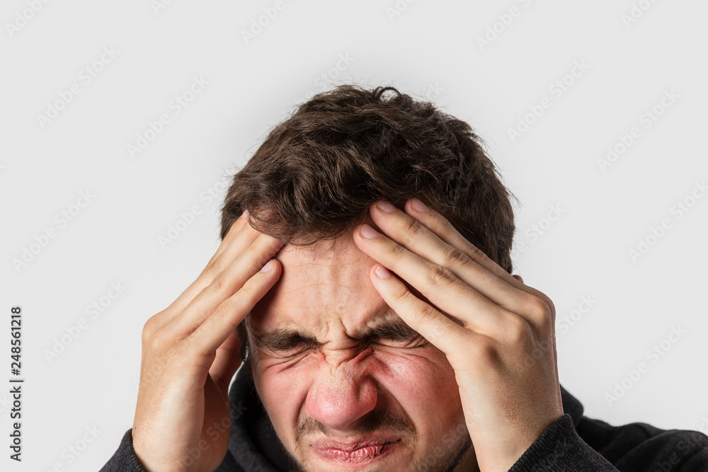 Young caucasian man having terrible head aches. Isolated on white background. Headaches concept. Young caucasian man having terrible head aches. Isolated on white background. Headaches concept.