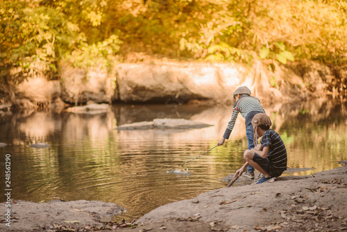 Little Asian boy fishing at the river vintage retro