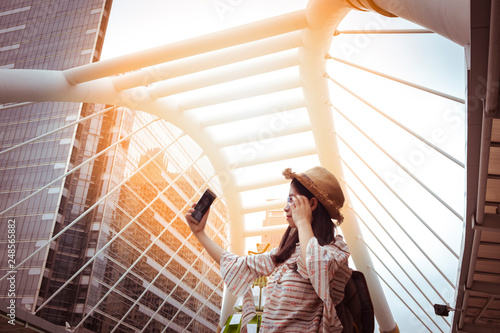 Photography Asian women tourist Playing Smartphone To check out the attractions in Bangkok, Thailand
