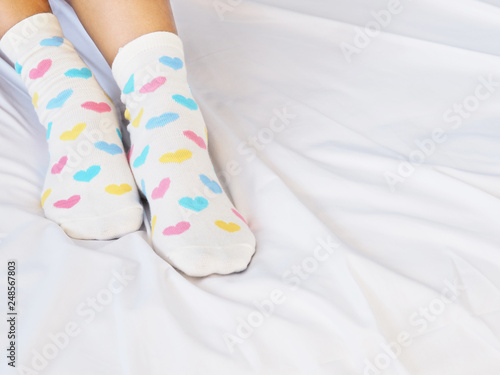 woman feet wearing white sock with pastel heart shape pattern