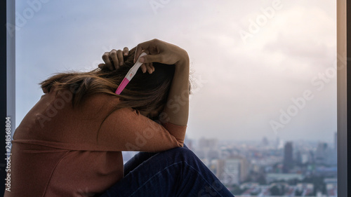 Photography Unhappy young asian woman holding pregnancy test showing a positive result, Wellness and healthy concept, Abortion problem, Selective focus