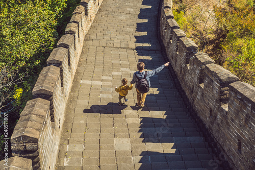 Canvas Print Happy cheerful joyful tourists dad and son at Great Wall of China having fun on travel smiling laughing and dancing during vacation trip in Asia