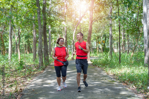 Fototapeta Naklejka Na Ścianę i Meble -  Happy asian mother and son jogging running in the park, Elderly care exercise sport activity concept