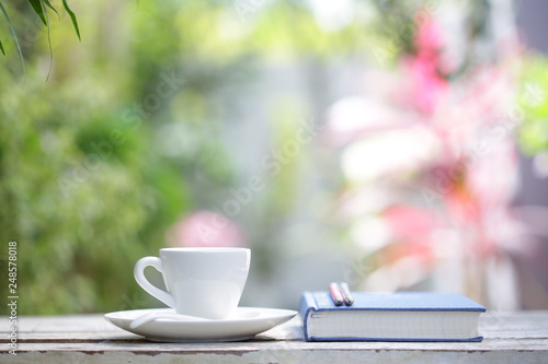 White coffee cup with plant and notebook