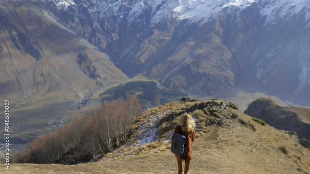 female traveler is walking along a mountain path female traveler is walking along a mountain path