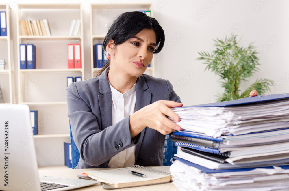 Middle aged businesslady unhappy with excessive work Middle aged businesslady unhappy with excessive work