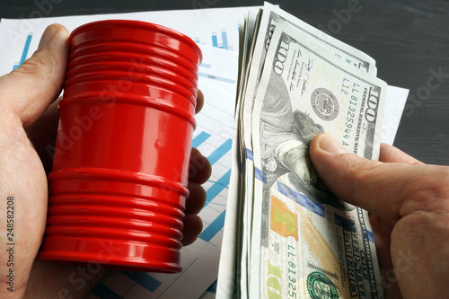 Slika na platnu Hands are holding barrel and money. Oil trading.