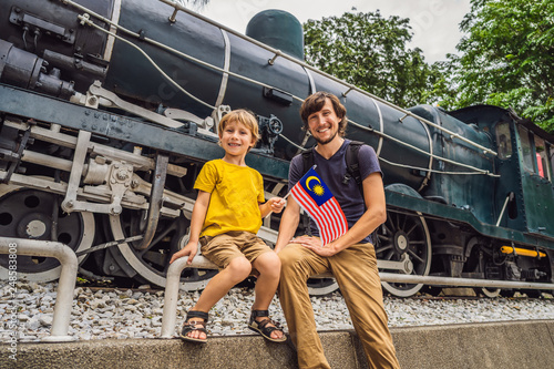 Canvas Print Father and son travelers in malaysia with malaysia flag celebrating the Malaysia independence day and Malaysia day