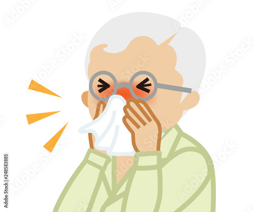 Senior man blowing nose with a tissue