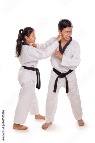 Female karateka hits male opponent face, full length portrait