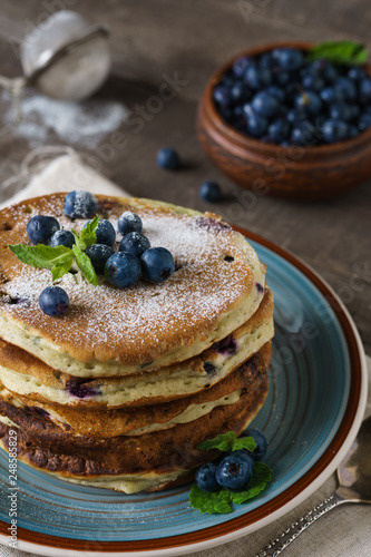 Pancakes with blueberries, mint and powdered sugar.