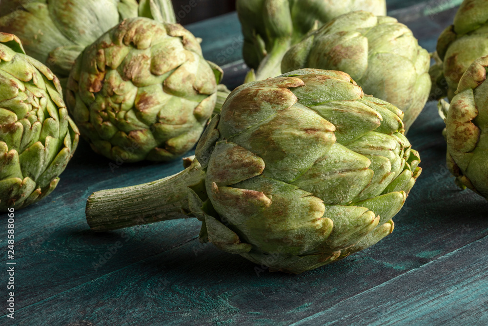 Obraz premium A closeup of a globe artichoke on a rustic wooden background