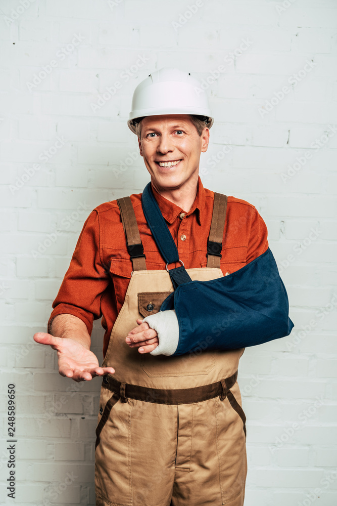 repairman with arm bandage standing on white textured background repairman with arm bandage standing on white textured background