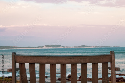 A lonely wooden bench overlooking the south african wavy ocean; peace of mind concept