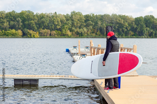 Surfer in warm clothes going to surfing