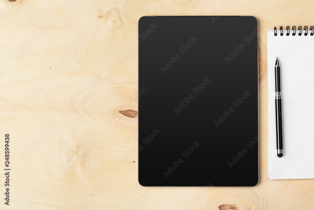 Tablet with notepad on wooden background Tablet with notepad on wooden background